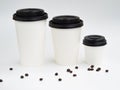 From small to big a line of white paper cups with coffee beans isolated on white. Coffee shop mockup with copyspace Royalty Free Stock Photo