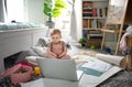 Small toddler girl on floor at home, watching story tales on laptop.