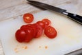 Small tomato chopped on synthetic cutting surface. Royalty Free Stock Photo