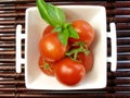 Small tomatoes with a leaf of basil Royalty Free Stock Photo