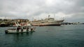 A small tourist boat sails along Sevastopolskoy Bay past the hospital ship `Yenisey`