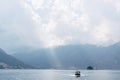 A small tourist boat sails on the Bay of Kotor with the islands in the background near Perast in Montenegro, against the Royalty Free Stock Photo