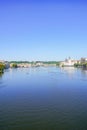 Small tourist boats on Vltava River surrounded by green river ba