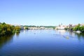 Small tourist boats on Vltava River surrounded by green river ba