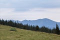 Small tourist tent on grassy mountain hill. Summer camping in mountains at dawn. Tourism concept Royalty Free Stock Photo