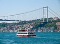 Small touristic cruise ship with passengers at Bosporus strait residential buildings and second Bosporus bridge at coast