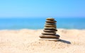 Small tower of flat stones on the sand against the background of the sea Royalty Free Stock Photo