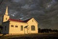 Small town church with oncoming storm