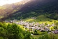 Small town in green summer valley surrounded by mountains in Swiss alps