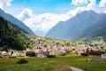 Small town in green summer valley surrounded by mountains in Swiss alps