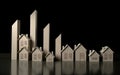 Small toy cardboard houses with arrow graph in the background