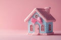 Small toy house decorated with pink bow on a pink background. Copy space for text Royalty Free Stock Photo