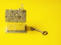 Small toy house with glitter on yellow color background and old style key Copy space. Dreaming of glamourous high end fantasy home