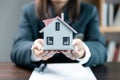 Small toy house in hands, close up of female hands sheltering modern house, get insurance or loan real estate or property. Royalty Free Stock Photo