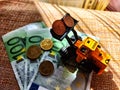 A small toy tractor or excavator on a bundle of money. The concept of the high cost of technology. The possibility of Royalty Free Stock Photo