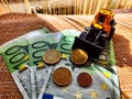 A small toy tractor or excavator on a bundle of money. The concept of the high cost of technology. The possibility of Royalty Free Stock Photo