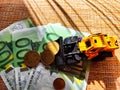 A small toy tractor or excavator on a bundle of money. The concept of the high cost of technology. The possibility of Royalty Free Stock Photo