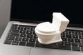 Small toy white toilet bowl on laptop keyboard. Concept of waste of time or busywork Royalty Free Stock Photo