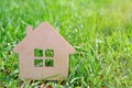 small toy wooden house on green grass, sunlight. Idea - photo to demonstrate mortgage, buying or renting real estate