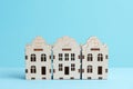 A small toy wooden houses on blue background. Affordable housing concept. Royalty Free Stock Photo