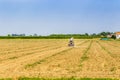 Small tractor plowing a large field