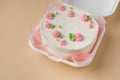 Small traditional Korean style bento cake with white cream cheese frosting decorated with pink whipped cream flowers. Little Royalty Free Stock Photo