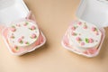 Small traditional Korean style bento cake with white cream cheese frosting decorated with pink whipped cream flowers. Little Royalty Free Stock Photo