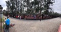 Small train station in Mordos Bay, passing trains, many people