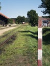 Small train station on narrow gauge. Village train station. Railroad tracks, railway traffic signs. Royalty Free Stock Photo