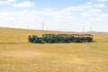 Small trains in Huanghuagou Huitengxile geological park near Hohhot, Inner Mongolia, China, with clouds and blue sky and wind