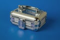 A small transparent closed suitcase on a blue background