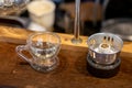 Small transparent glass, clear coffee mug with a handle placed on a wooden table Royalty Free Stock Photo