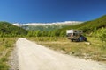 Small travel vehicle camping van is parked under huge mountain formation. Tourism vacation and travel. Camper van and