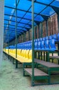 Small tribune with yellow and blue seats for spectators with a roof