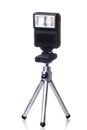 Small tripod with a flash for camera isolated over Royalty Free Stock Photo