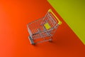 Small trolley on a orange and yellow foreground table. Blackfriday and cybermonday concept
