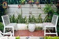 Small tropical house balcony with green plants in pots and white bench