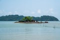 Small tropical island with trees and rocks in the middle of sea and cloudy blue sky background. Landscape beach view in Endau, Mal Royalty Free Stock Photo