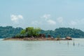 Small tropical island with trees and rocks in the middle of sea and cloudy blue sky background. Landscape beach view in Endau, Mal Royalty Free Stock Photo