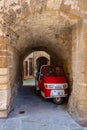 A small truck on the street of an old Italian town