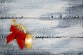 A small trumpet, a horn with a red bow on a worn blue wooden background. Christmas decorations.