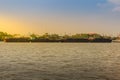 Small tugboat is pulling a large shipping barge up the Chao Phraya River in Bangkok, Thailand. Royalty Free Stock Photo