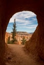 A small tunnel cutting through the sandstone a the stunning Bryce Canyon at the end of the tunnel is a view out across the canyon