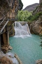 Small turquoise waterfall in a river