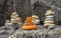 small turrets among rocks , flat stones stacked in little towers on black rock background , immersive travel concept landscape