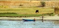 small typical Egyptian boat stranded on the riverbank with an adult watching and a chil