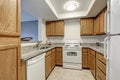 Small u shaped kitchen filled with wood cabinets Royalty Free Stock Photo