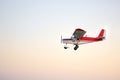 Small ultralight airplane with overhead wing and single propeller flying in sky. Such aircraft are used for recreational, sport Royalty Free Stock Photo