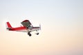 Small ultralight airplane with overhead wing and single propeller flying in sky. Such aircraft are used for recreational, sport Royalty Free Stock Photo