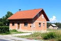 Small unfinished brick suburban family house with old wooden shed in background